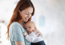 1…2…3…run to the wall! Freeze! Playful parenting baby in mother's arms